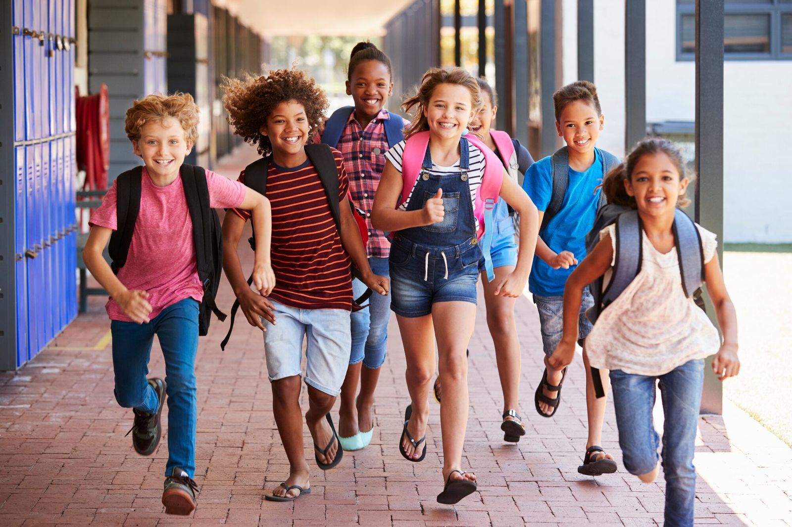 Students carrying backpacks at school.